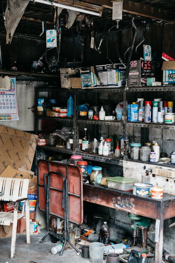 A messy garage interior showcasing shelves filled with various tools and supplies.